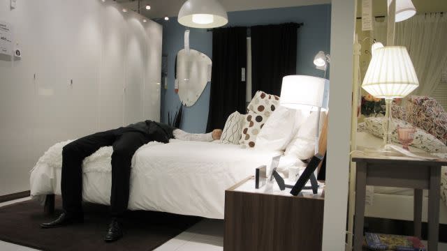 A man lies down on a bed in Sweden IKEA