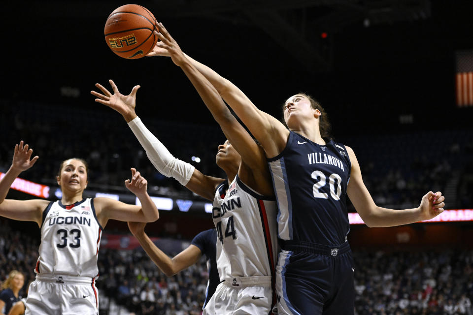 Villanova's Maddy Siegrist (20) reaches over UConn's Aubrey Griffin (44) as they vie for a rebound during the first half of an NCAA college basketball game in the finals of the Big East Conference tournament Monday, March 6, 2023, in Uncasville, Conn. (AP Photo/Jessica Hill)