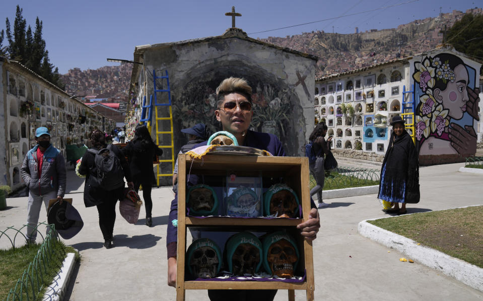 Una persona lleva una caja de calaveras humanas decoradas para ser bendecidas por un sacerdote durante la fiesta anual de las ñatitas, una tradición que marca el final de la festividad católica de Todos los Santos, en el Cementerio General de La Paz, Bolivia, el martes 8 de noviembre de 2022. (AP Foto/Juan Karita)