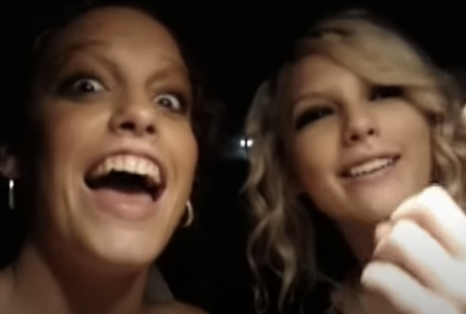 Two women smiling in a car, one with dark hair and the other blonde, both appearing joyful
