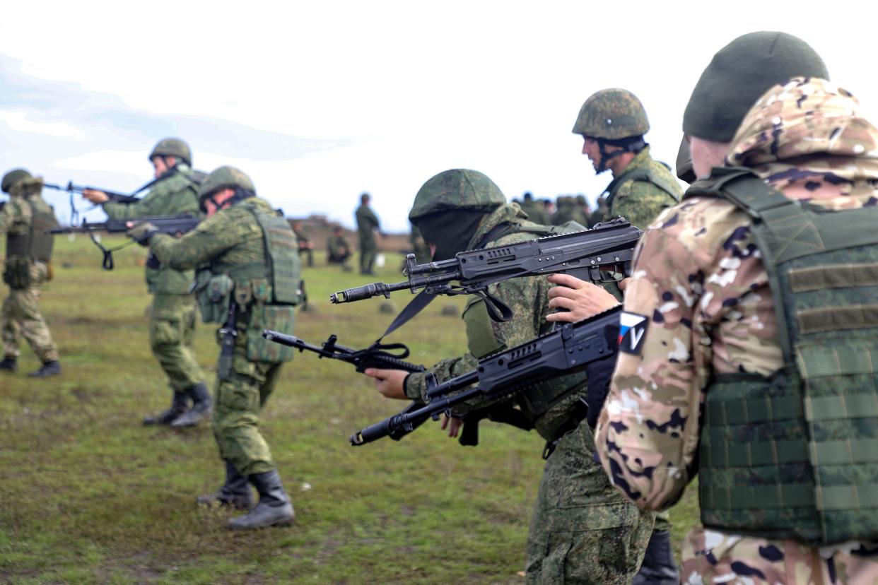Recruits hold their weapons during military training at a firing range in the Russian-controlled Donetsk region