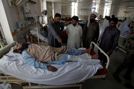 A man injured during kidnapping of two Chinese language teachers by unidentified gunmen lies on a hospital bed in Quetta, Pakistan May 24, 2017. REUTERS/Naseer Ahmed