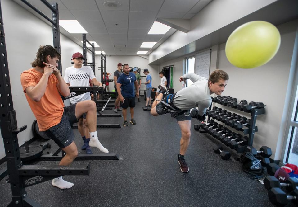 Pensacola News Journal sports reporter Lucas Semb, right, performs a throwing sock drill while working out with the baseball team at L.E.A.D. Academy in Pace on Monday, July 11, 2022.