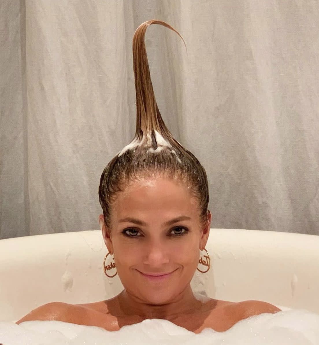 Jennifer Lopez has a laugh in the tub while enjoying "#SelfcareSunday #tubtime" on March 7, 2021.