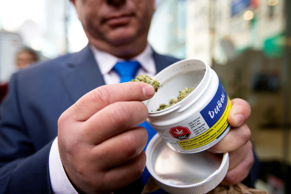 A man shows off his cannabis purchase outside the Quebec Cannabis Society (SQDC) store, on the day Canada legalizes recreational marijuana, in Montreal, Quebec, Canada, October 17, 2018.  REUTERS/Christinne Muschi