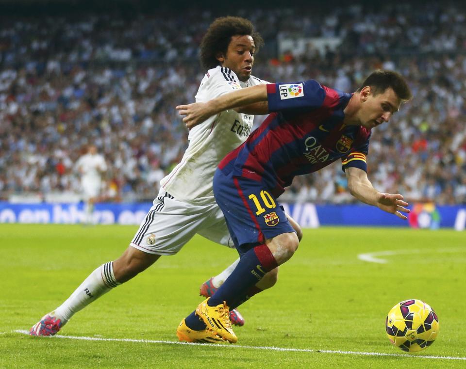 Barcelona's Lionel Messi (R) is challenged by Real Madrid's Marcelo during their Spanish first division "Clasico" soccer match at the Santiago Bernabeu stadium in Madrid October 25, 2014. REUTERS/Juan Medina (SPAIN - Tags: SOCCER SPORT)