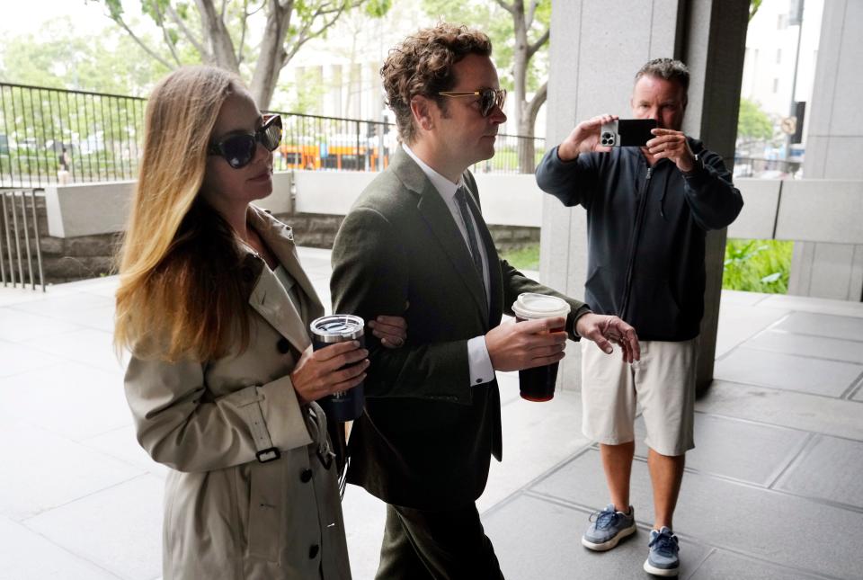 Danny Masterson, center, and his wife Bijou Phillips, left, arrive for closing arguments in his second trial in Los Angeles on May 16, 2023.