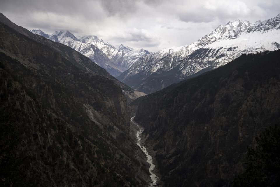 The Sutlej River flows in the valley below the tall snowy peaks in the Kinnaur district of the Himalayan state of Himachal Pradesh, India, Monday, March 13, 2023. The Sutlej River is now dry in patches. (AP Photo/Ashwini Bhatia)