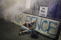 A demonstrator hides under a barrier as federal officers release tear gas during a Black Lives Matter protest at the Mark O. Hatfield United States Courthouse, July 29, 2020, in Portland, Ore. The image was part of a series of photographs by The Associated Press that won the 2021 Pulitzer Prize for breaking news photography. (AP Photo/Marcio Jose Sanchez)