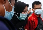 Family members of the passengers of Sriwijaya Air flight SJ 182, which crashed into the sea, mourn as they visit the site of the crash to pay their tribute, on the deck of Indonesia's Naval ship KRI Semarang, at the sea off the Jakarta coast