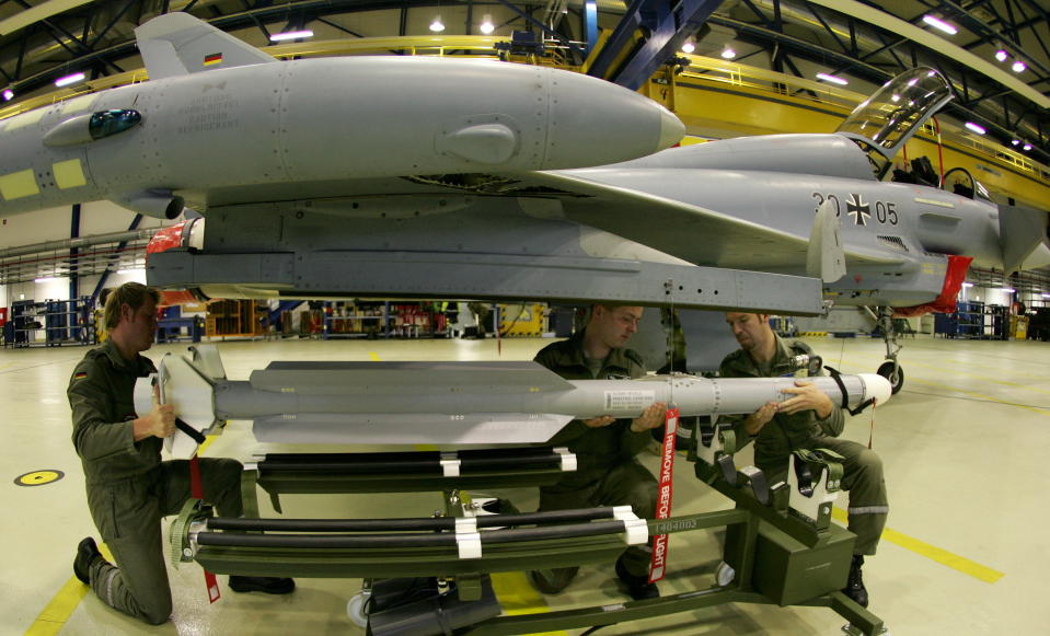 Die technischen Unteroffiziere der deutschen Luftwaffe Stefen Braun, Martin Radtke und Jan Reschke (v.l.n.r.) befestigen eine neue Luft-Luft-Rakete IRIS-T (Infraread Imaging System - Tail/Thrust Vector Controlled) an einem Eurofighter-Flugzeug am Jagdgeschwader 73 Luftwaffenstützpunkt in Laage, Norddeutschland, 5. Dezember 2005. 