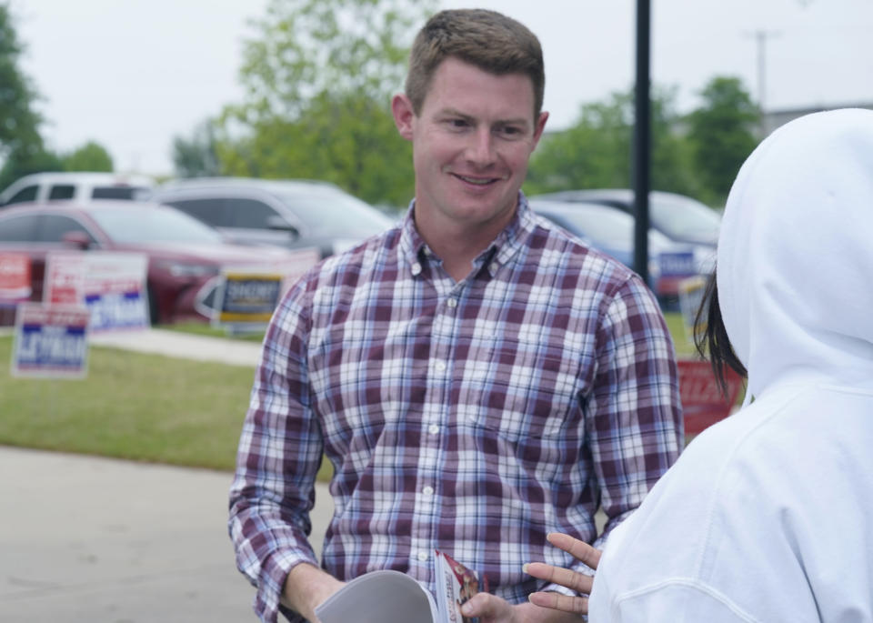 Texas congressional candidate Michael Wood, left, smiles as he listens to potential voter Yvette Williams outside an early voting location Tuesday, April 27, 2021, in Mansfield, Texas. Wood is considered the anti-Trump Republican Texas congressional candidate that Illinois Congressman Adam Kinzinger has endorsed in the May 1st special election for the 6th Congressional District. (AP Photo/LM Otero)