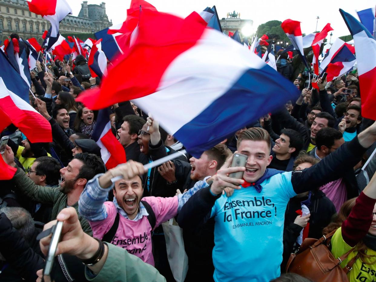 Supporters of French President Elect Emmanuel Macron celebrate near the Louvre museum after early results were announced in the second round vote in the 2017 presidential elections in Paris, France, May 7, 2017.