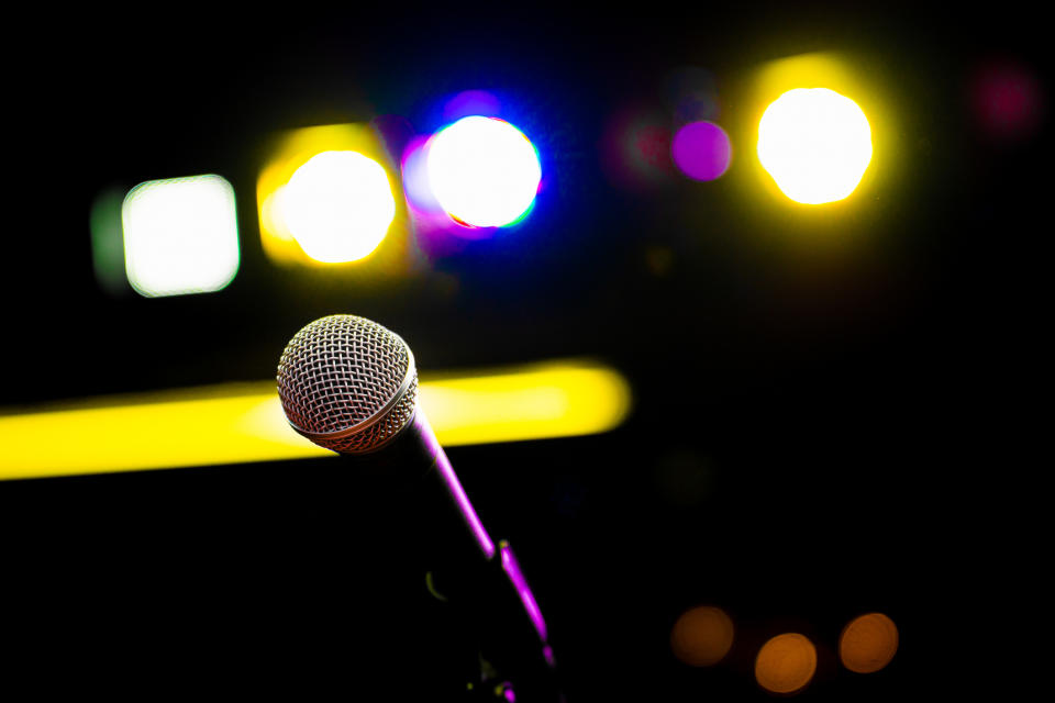 Microphone on stand with out-of-focus stage lights in the background