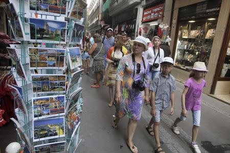 A group of tourists walk through the streets in downtown Valencia, Spain, July 23, 2015. REUTERS/Heino Kalis