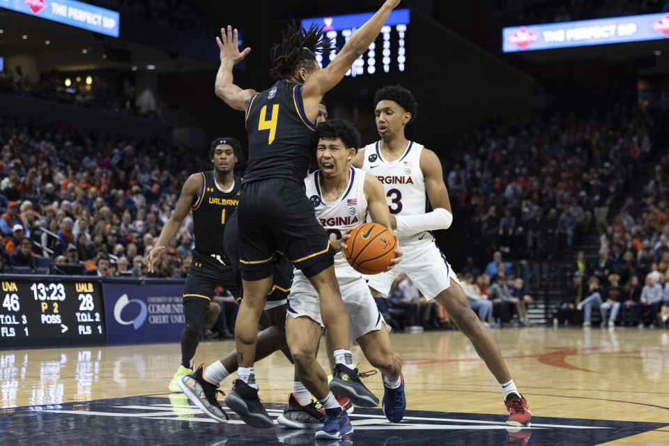 Virginia's Kihei Clark (0) drives to the basket as Albany's Malik Edmead defends during the second half of an NCAA college basketball game in Charlottesville, Va., Wednesday, Dec. 28, 2022. (AP Photo/Mike Kropf)