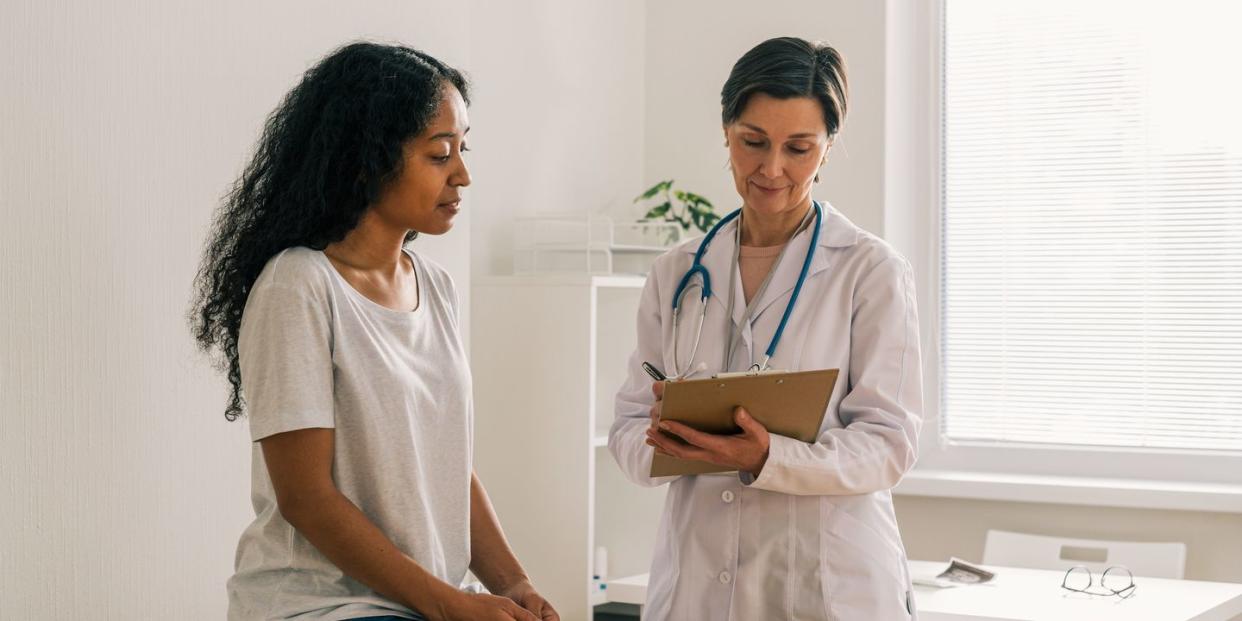 african american female listening carefully to advice and recommendations of doctor healthcare consultation and examination in medical clinic office prescribing medications and treatment