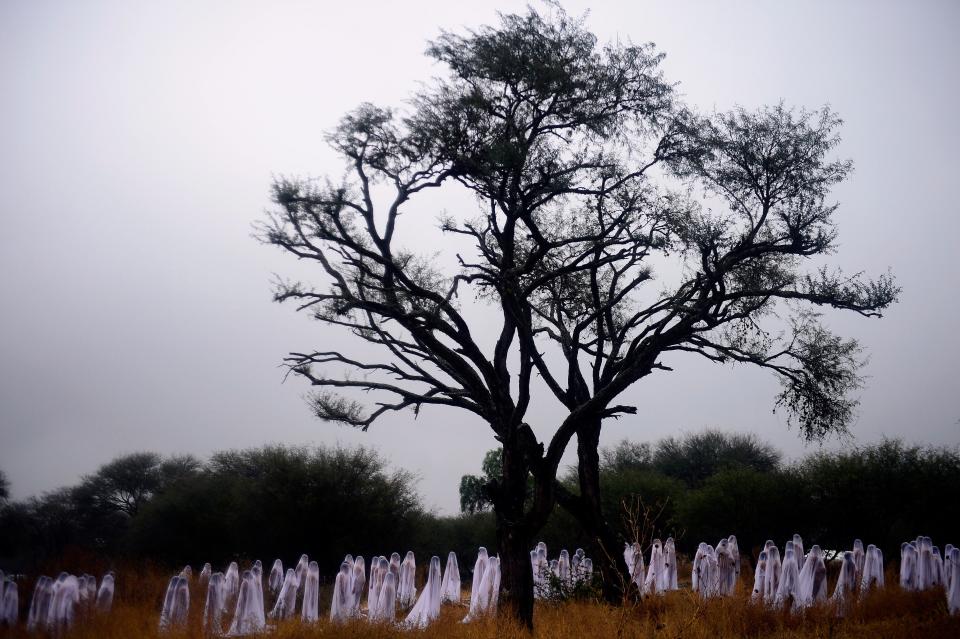 Naked volunteers perfom for Tunick (out of frame) at Los Senderos Villages in San Miguel de Allende municipality, Guanajuato State, Mexico on November 4, 2012. Tunick was in Mexico for one day to make this performance commemorating the Day of the Dead.