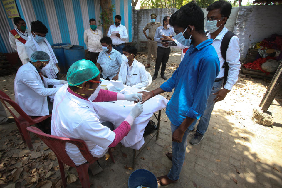 A doctor takes a blood sample of a student arrived from Kota by buses , managed by Uttar Pradesh government ,for Rapid Covid test ,in an isolation centre ,during the extended nationwide lockdown imposed by Government as a preventive measure against COVID-19 corona virus, in Allahabad, India on April 19, 2020.  (Photo by Ritesh Shukla/NurPhoto via Getty Images)