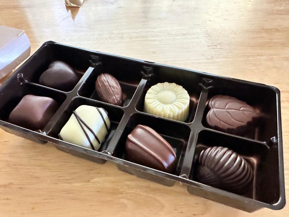 Open box of trader joe's Belgian truffles on white wooden table