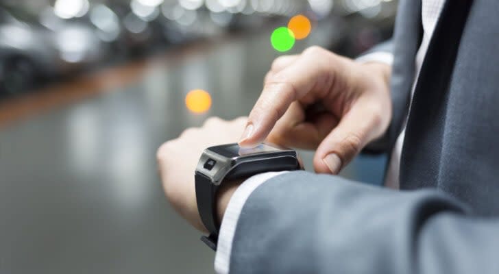 Man in suit wearing tech watch representing Wearable Devices (WLDS) stock