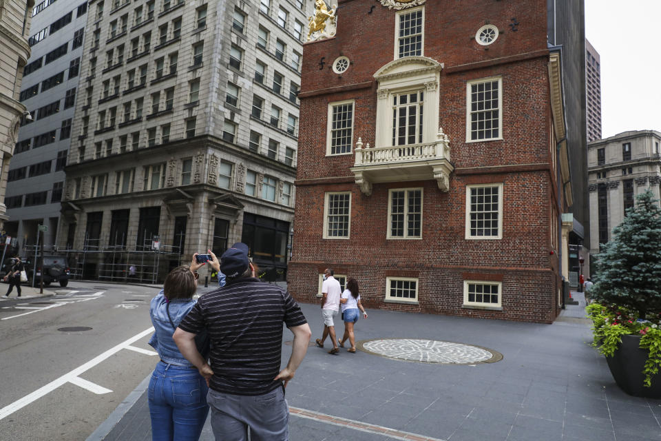 BOSTON - JULY 3: Tourists take a picture of the Old State House, a Boston landmark, on July 3, 2020. On the eve of Fourth of July, crowds were sparse in front of the Old State House as a result of the coronavirus restricting travel. (Photo by Erin Clark/The Boston Globe via Getty Images)