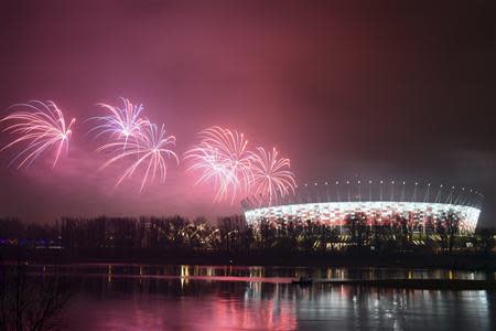Fireworks explode next to the National Stadium during New Year celebrations in Warsaw
