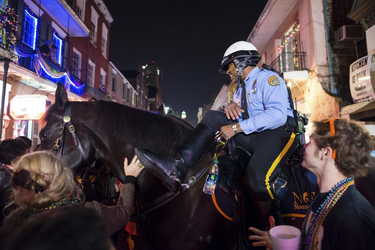 New Orleans, Louisiana, USA - February 8, 2013: A mounted New Orleans police officer pauses in the middle of Bourbon Street for Mardi Gras revelers to pet his horse.