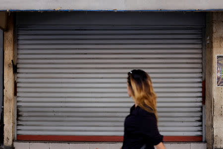 A woman walks past closed stores in Caracas, Venezuela September 14, 2018. REUTERS/Marco Bello