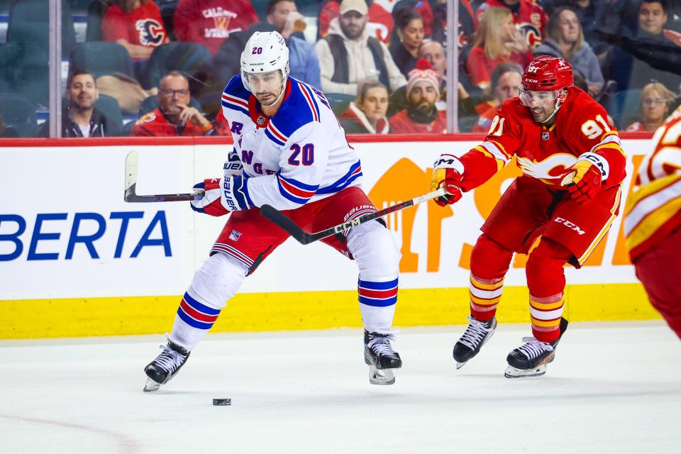 Oct 24, 2023; Calgary, Alberta, CAN; New York Rangers left wing Chris Kreider (20) controls the puck in front of Calgary Flames center Nazem Kadri (91) during the first period at Scotiabank Saddledome.