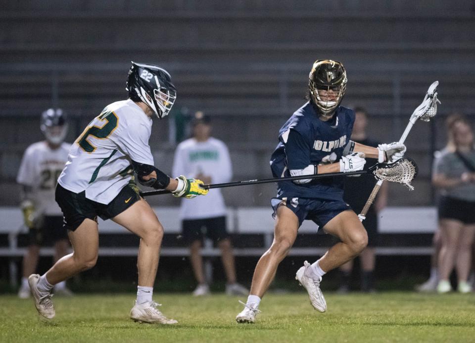 Pierce Martin (9) controls the ball during the Gulf Breeze vs Catholic boys lacrosse game at Pensacola Catholic High School on Friday, March 31, 2023.