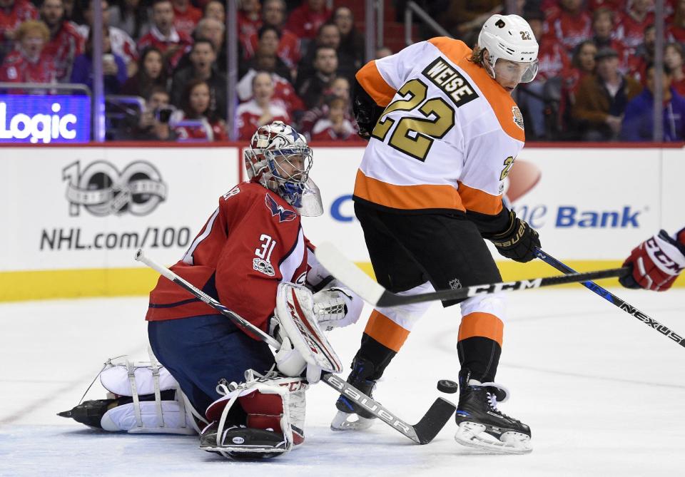 Philadelphia Flyers right wing Dale Weise (22) and Washington Capitals goalie Philipp Grubauer (31), of Germany, look for the puck during the second period of an NHL hockey game, Sunday, Jan. 15, 2017, in Washington. (AP Photo/Nick Wass)