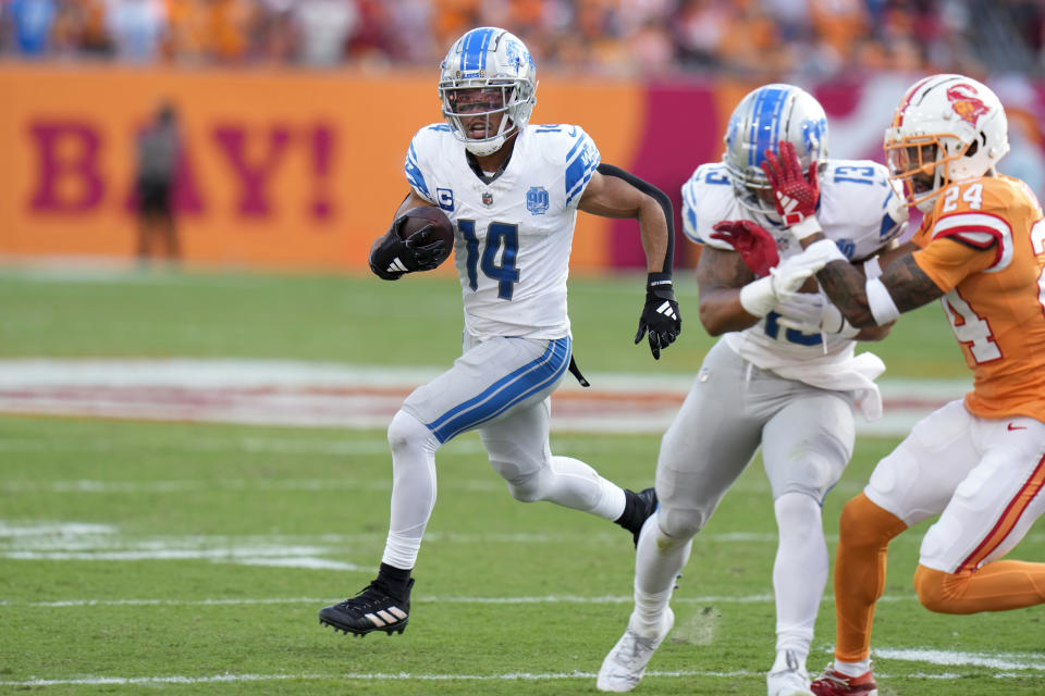 Detroit Lions wide receiver Amon-Ra St. Brown (14) scores on a 27-yard touchdown reception as running back Craig Reynolds (13) blocks Tampa Bay Buccaneers cornerback Carlton Davis III (24) during the first half of an NFL football game Sunday, Oct. 15, 2023, in Tampa, Fla. (AP Photo/Chris O'Meara)