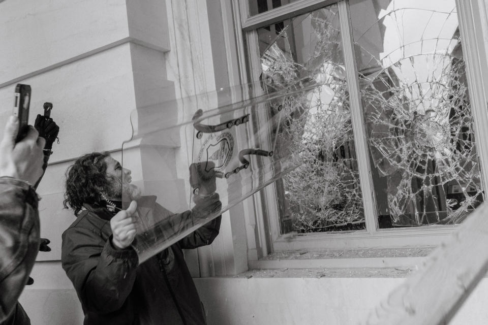 Pro-Trump rioter uses a Capitol Police shield to break through a window at the Capitol building.<span class="copyright">Christopher Lee for TIME</span>