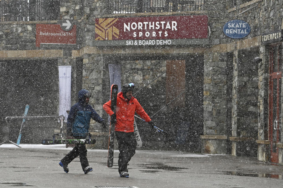 Skiers hurry along The Village at Northstar California Resort as snow falls on Thursday, Feb. 29, 2024, in Truckee, Calif. The most powerful Pacific storm of the season started barreling into the Sierra Nevada on Thursday, packing multiple feet of snow and dangerous winds that forecasters say will create blizzard conditions likely to close major highways and trigger power outages into the weekend.(AP Photo/Andy Barron)