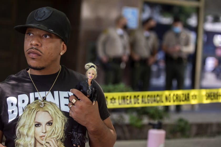 LOS ANGELES, CA - JULY 14: Derrick Daniels, 32, of Las Vegas is holding a Britney Spears doll and is part of a crowd of about 150 people supporting Britney Spears stood outside a courthouse, holding signs and chanting in Los Angeles, CA today. Britney Spears' conservatorship case resumes after last month's explosive testimony on Wednesday, July 14, 2021. A crowd of about 150 people supporting Britney Spears stood outside a courthouse, holding signs and chanting.The singer's personal and financial affairs have been monitored by a judge since early 2008, when she exhibited bizarre public behavior. Spears recently told a judge she wants the conservatorship ended. She was not at this court house. (Francine Orr / Los Angeles Times)