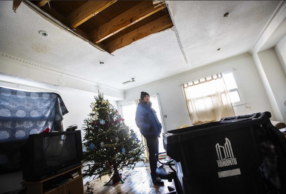 REFILE - CLARIFYING SECOND SENTENCE Shamus Cameron looks at a ceiling in his home where a pipe burst following an ice storm in Toronto, December 27, 2013. Cameron was forced to leave his home after the fire department condemned the house. Over 30,000 homes and businesses are still without power in North America's fourth largest city, according to the utility company Toronto Hydro. REUTERS/Mark Blinch (CANADA - Tags: ENVIRONMENT)