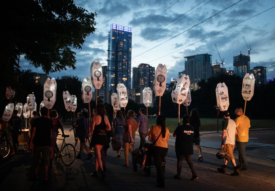 The East Austin Ghost Procession carries lanterns with images representing neighborhood memories as it heads toward Rainey Street.