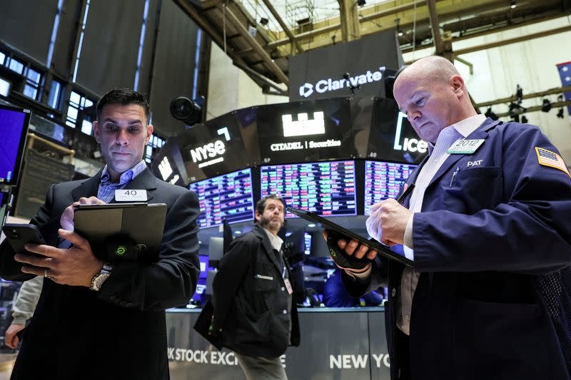 FILE PHOTO: Traders work on the floor of the NYSE in New York