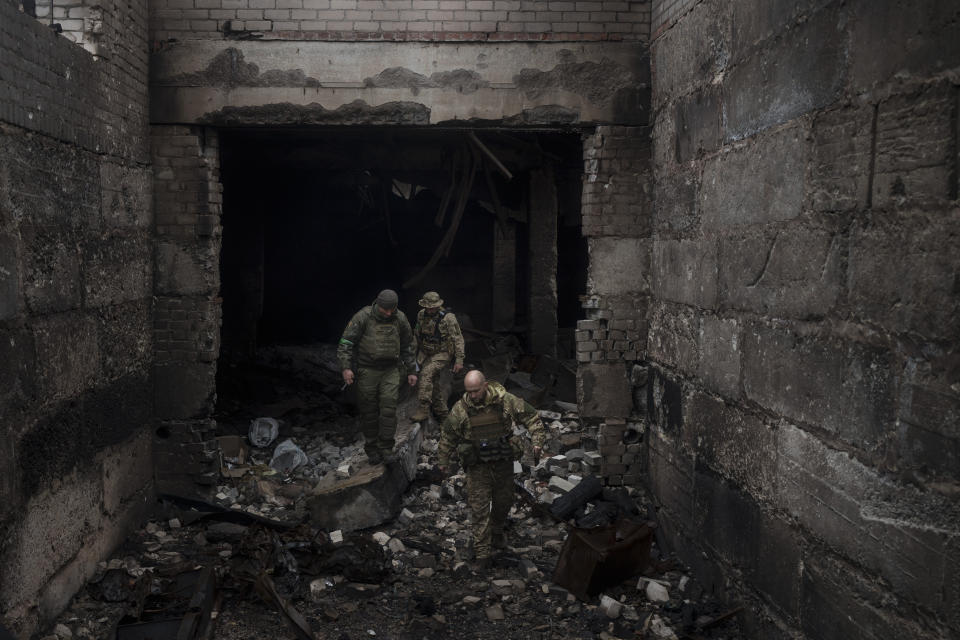 Ukrainian soldiers walk in a building previously used by Russian soldiers as a temporary base in Malaya Rohan, on the outskirts of Kharkiv, Ukraine, Tuesday, April 12, 2022. (AP Photo/Felipe Dana)