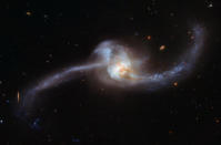 <p>This image, captured by the NASA/ESA Hubble Space Telescope and released Oct. 20, 2017, shows the twisted cosmic knot NGC 2623 — or Arp 243 and is located about 250 million light-years away in the constellation of Cancer (The Crab). NGC 2623’s unusual shape is the result of a collision and merger between two galaxies. This encounter caused clouds of gas to become compressed and stirred up, triggering a sharp spike of star formation. (Photo: NASA/ESA Hubble Space Telescope/Handout via Reuters) </p>