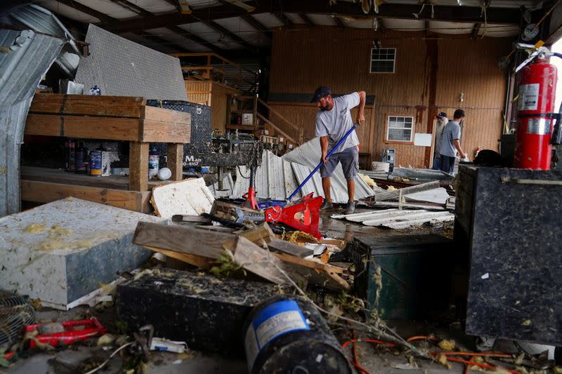 Brent Morvant cleans up his paint and body shop after Hurricane Laura passed through the area in Cameron Parish