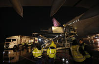 FILE - In this Wednesday, Feb. 10, 2021 file photo, workers unload a container of China's Sinopharm coronavirus vaccines at the Belgrade Airport in Serbia. China is providing the vaccine to countries such as Serbia and Hungary -- a significant geopolitical victory in Central Europe and the Balkans, where the West, China and Russia are competing for political and economic influence. (AP Photo/Darko Vojinovic)