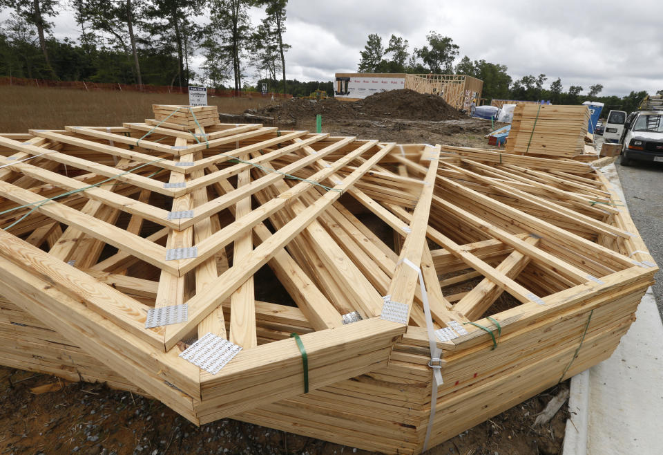 FILE - In this June 13, 2019, file photo stacks of building materials are stacked up near new home under construction in Mechanicsville, Va. On Friday, Aug. 23, the Commerce Department reports on sales of new homes in July. (AP Photo/Steve Helber, File)