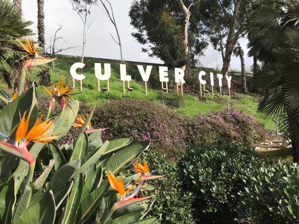 The Culver City Sign in Los Angeles, California, on a green hill with flowers.