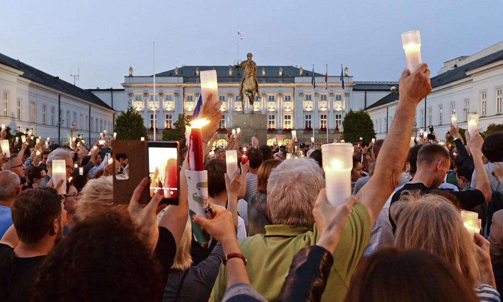 Protesters raise candles during a protest on 18 July in front of the presidential palace.
