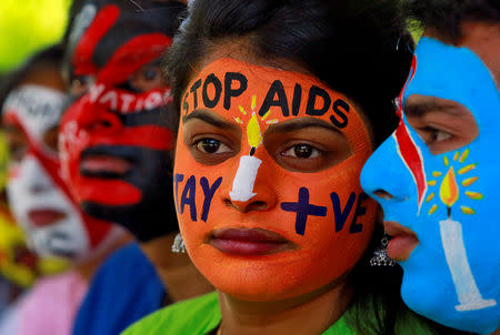 FILE PHOTO: Students with their faces painted with messages pose during an HIV/AIDS awareness campaign to mark the International AIDS Candlelight Memorial, in Chandigarh, India, May 20, 2018. REUTERS/Ajay Verma/File Photo