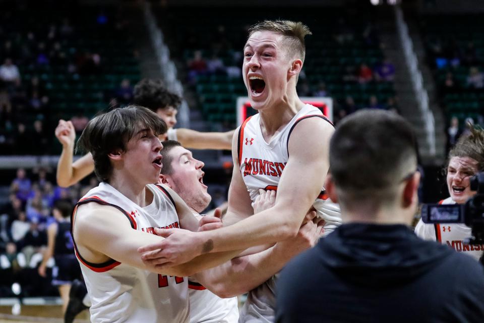 Munising guard Kane Nebel (0) celebrates with teammates after the 39-37 win over Wyoming Tri-unity Christian at the MHSAA boys Division 4 final at Breslin Center in East Lansing on Saturday, March 25, 2023.