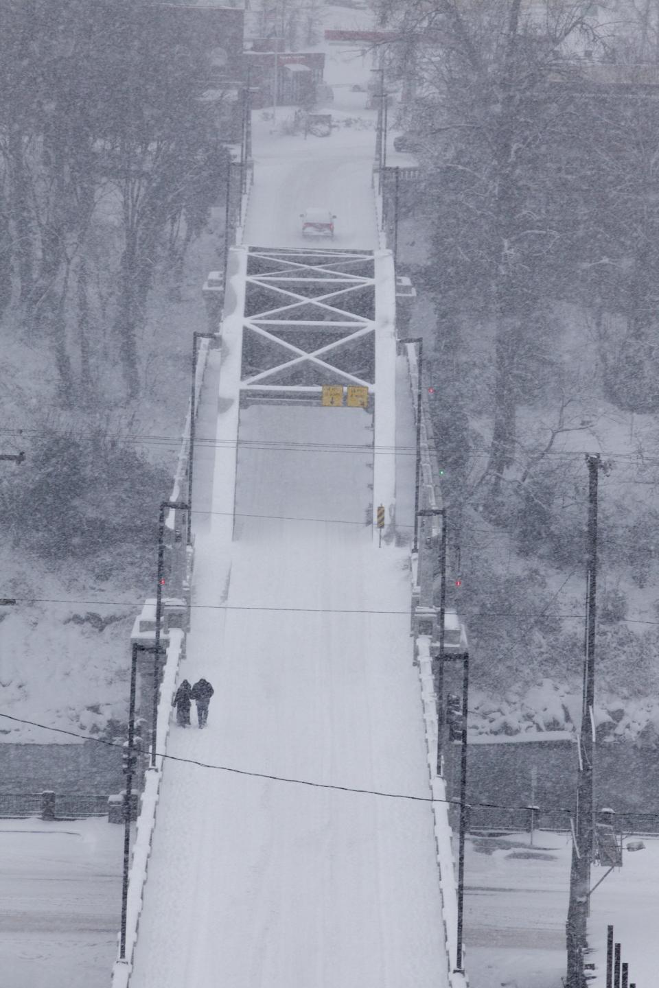 People walk across the bridge from West Linn to Oregon City which was the safest choice. Snow blasted Clackamas County Saturday, Feb. 8, 2014. (AP Photo/The Oregonian, Michael Lloyd)