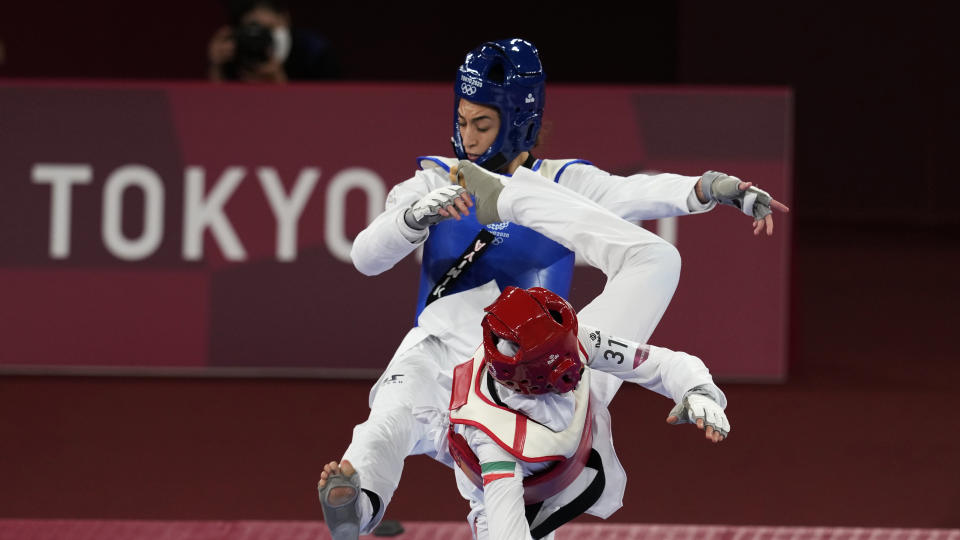 <p>Iran's Nahid Kiyani, front, attacks Kimia Alizadeh Zonoozi, of the Refugee Olympic Team, during the women's 57kg match at the 2020 Summer Olympics, Sunday, July 25, 2021, in Tokyo, Japan. (AP Photo/Themba Hadebe)</p> 